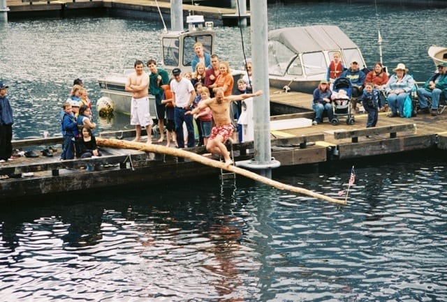 A man is balancing on a long pole