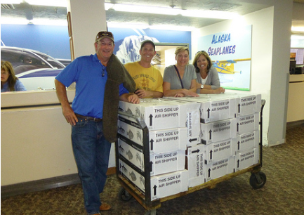 A group of people standing around boxes in a room.