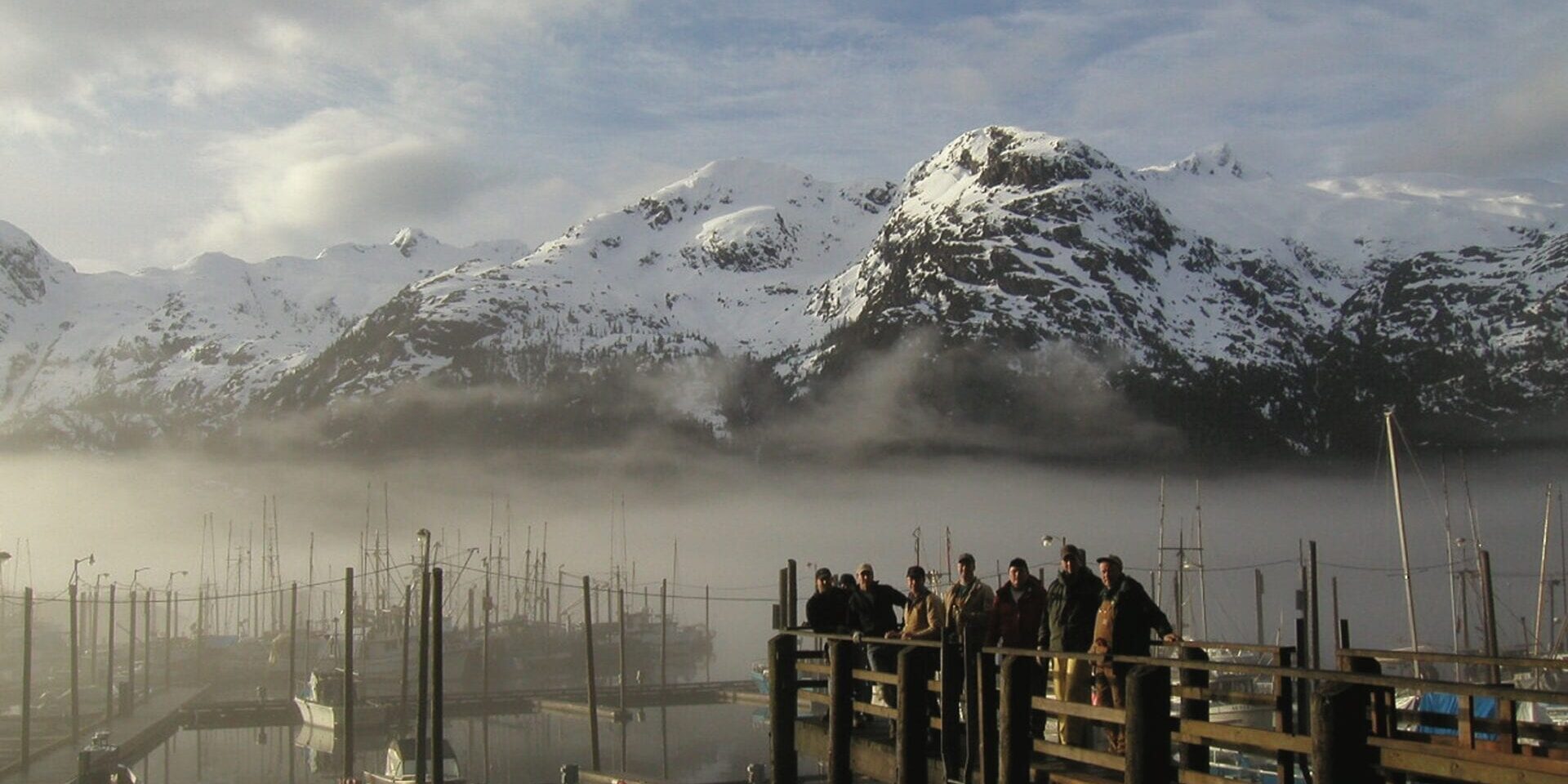 A group of people standing on top of a dock.