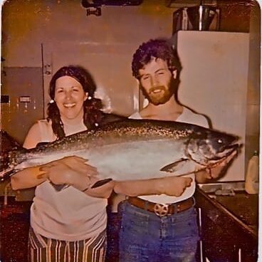 A man and woman holding a large fish.