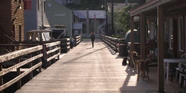 A person walking down the street on a wooden walkway.